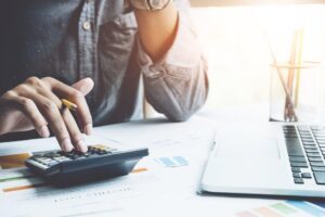 Close up a man working about financial with calculator at his office to calculate expenses, Accountigng concept